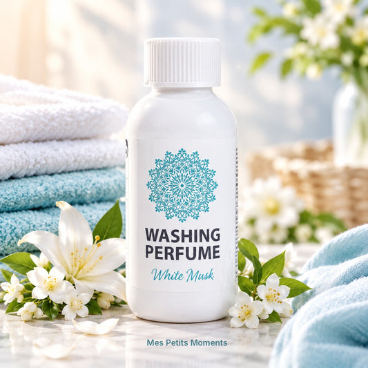 Flacon de parfum de linge Daili Musc Blanc 150 ml posé sur du marbre, avec serviettes et fleurs blanches
